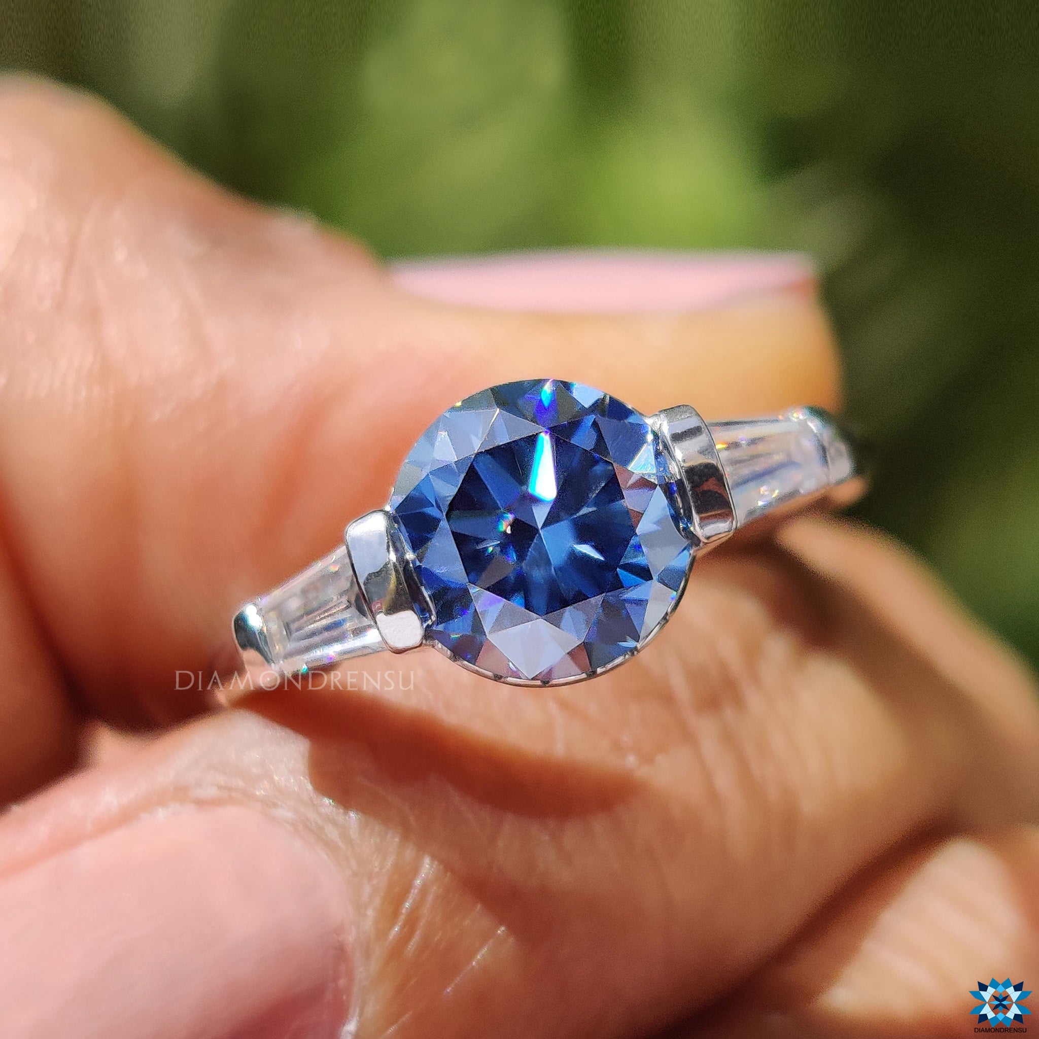 Handmade jewellery ring featuring dark blue moissanite and side stones.
