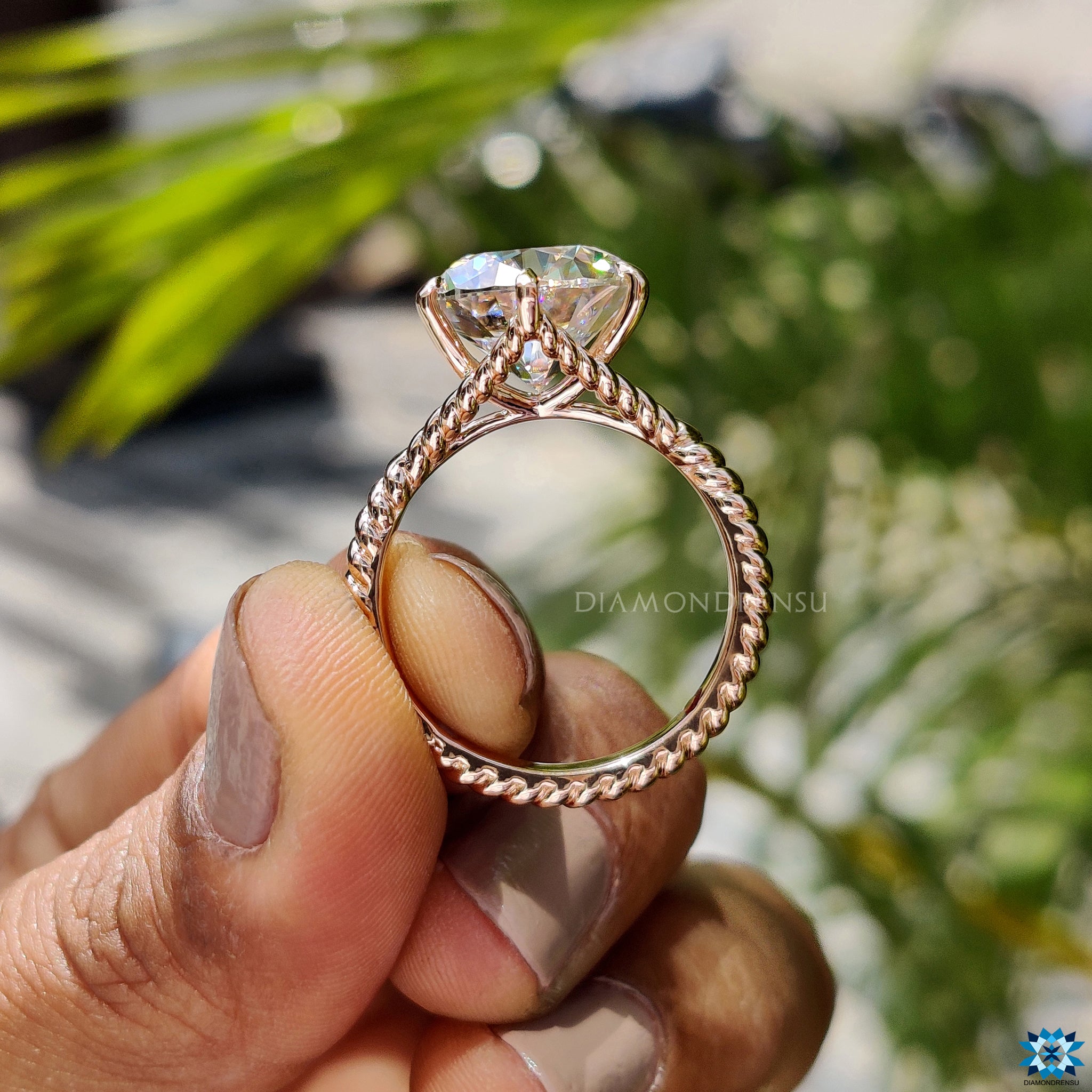 Custom moissanite engagement ring in rose gold with claw setting.
