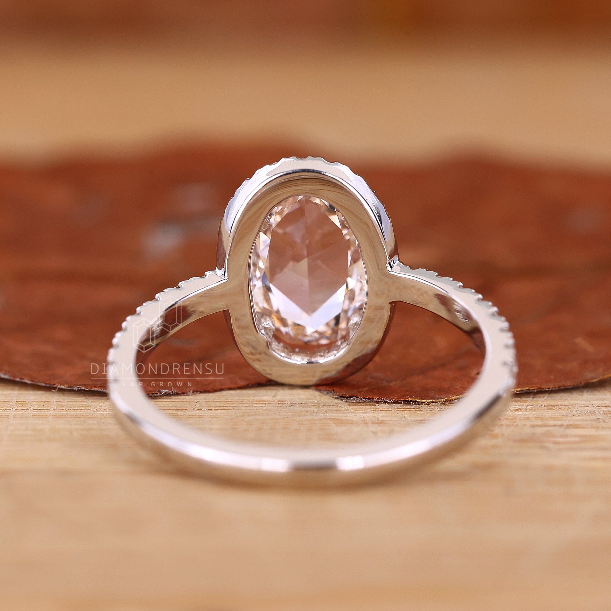 White gold ring styled as oval rose cut diamond engagement ring.
