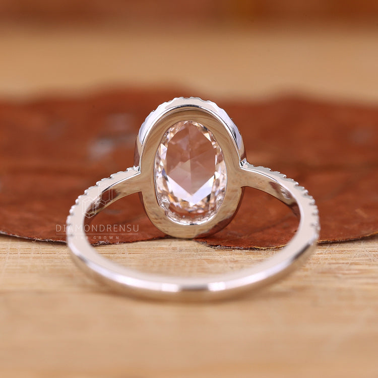 White gold ring styled as oval rose cut diamond engagement ring.

