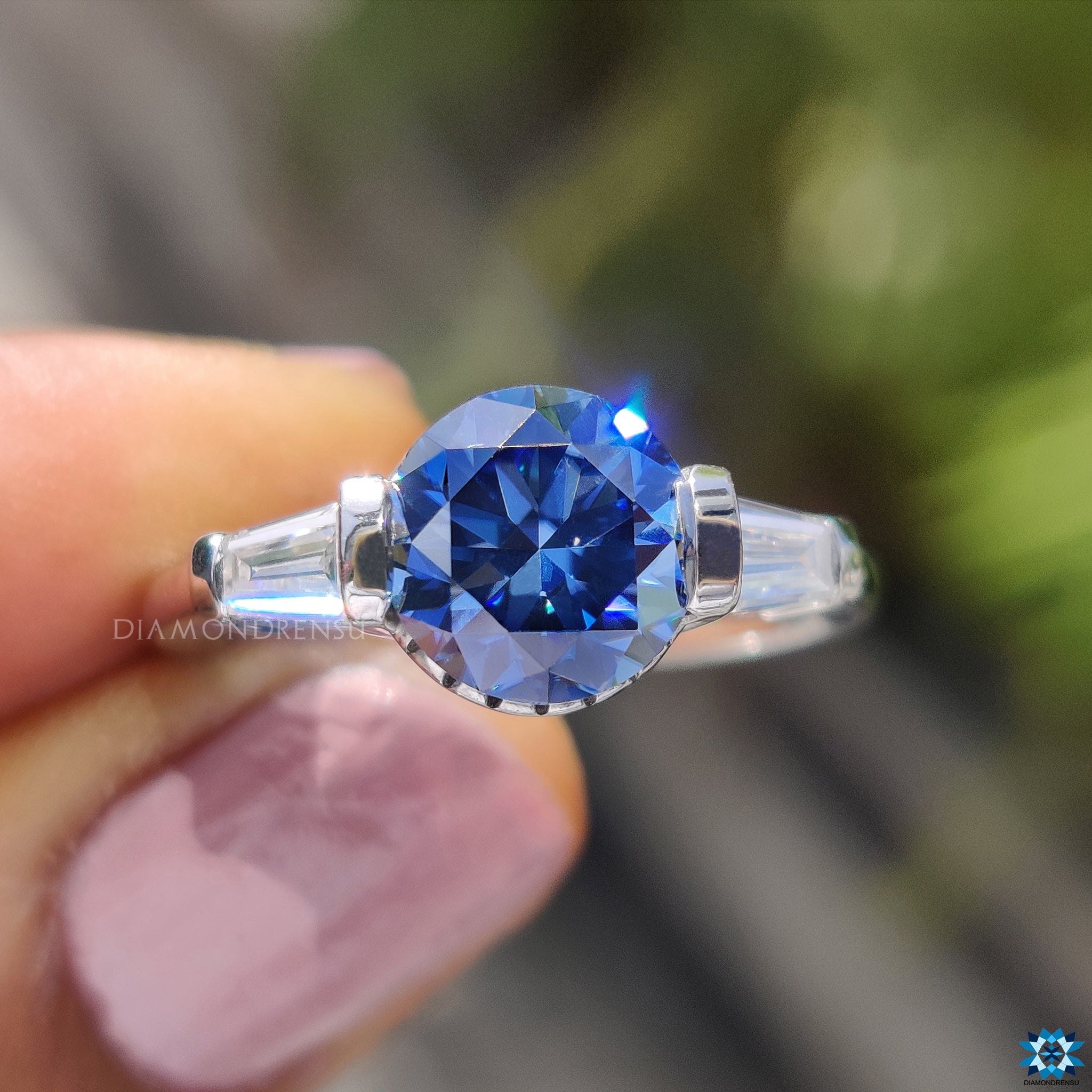 UK engagement ring with baguette side stones and centre blue gem.
