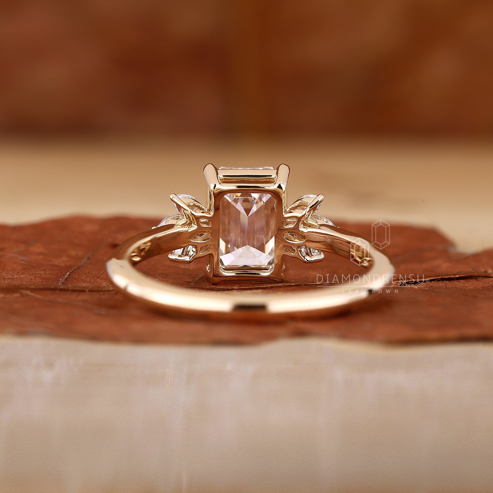 UK engagement ring with emerald cut center.
