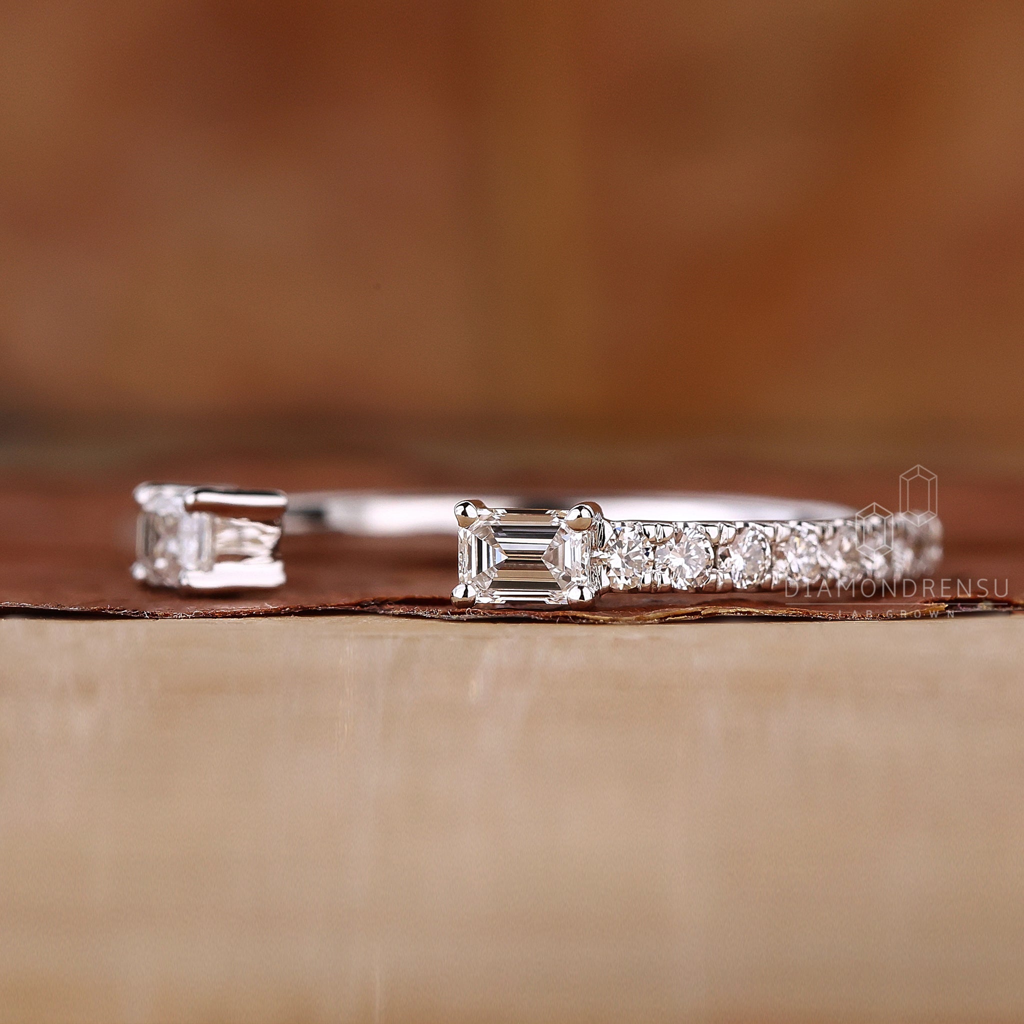 Handmade white gold wedding band with emerald and round stones

