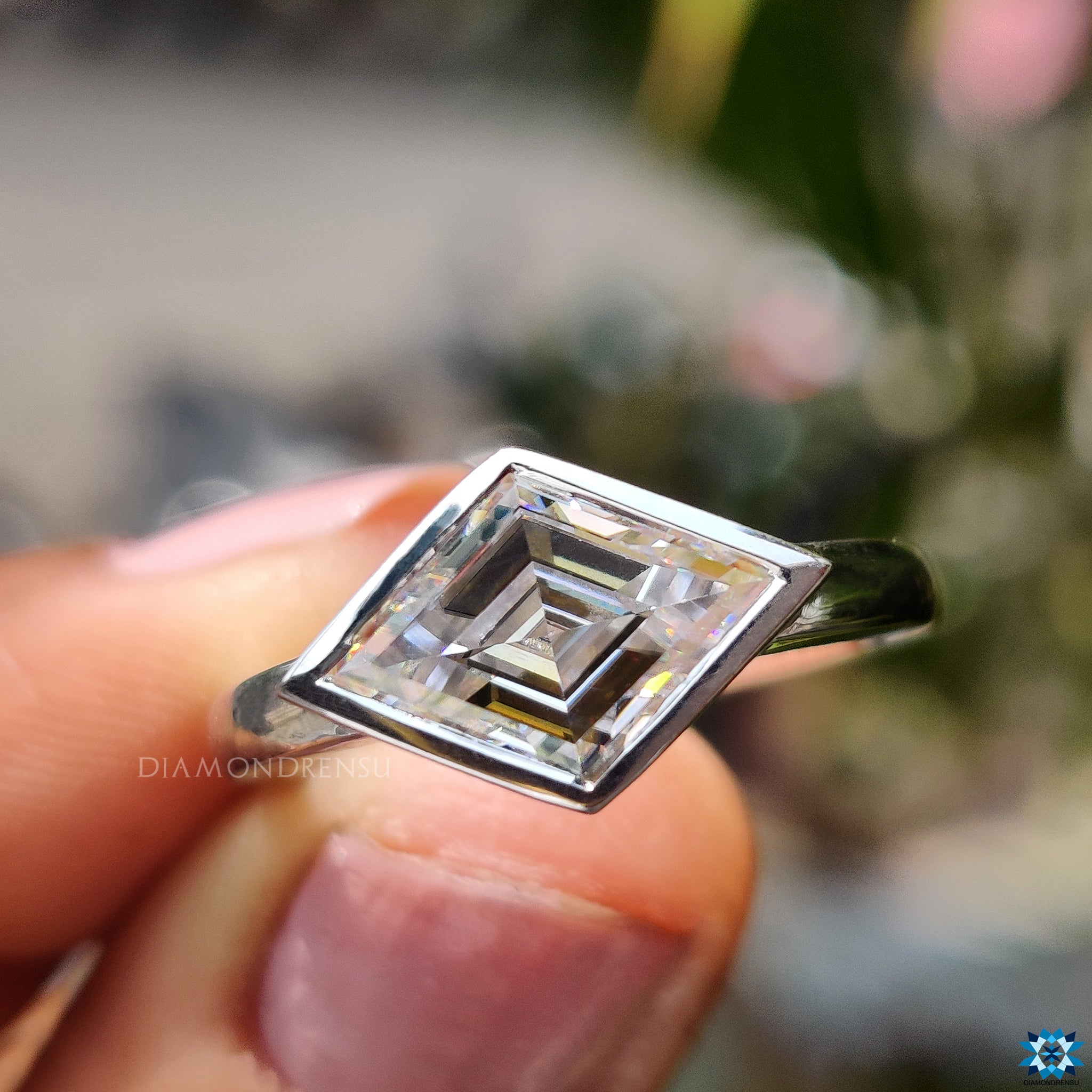 Bezel set lozenge cut moissanite ring.

