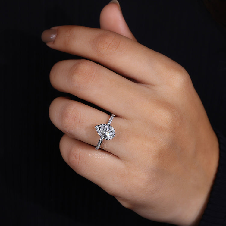 Pear ring with halo engagement style.
