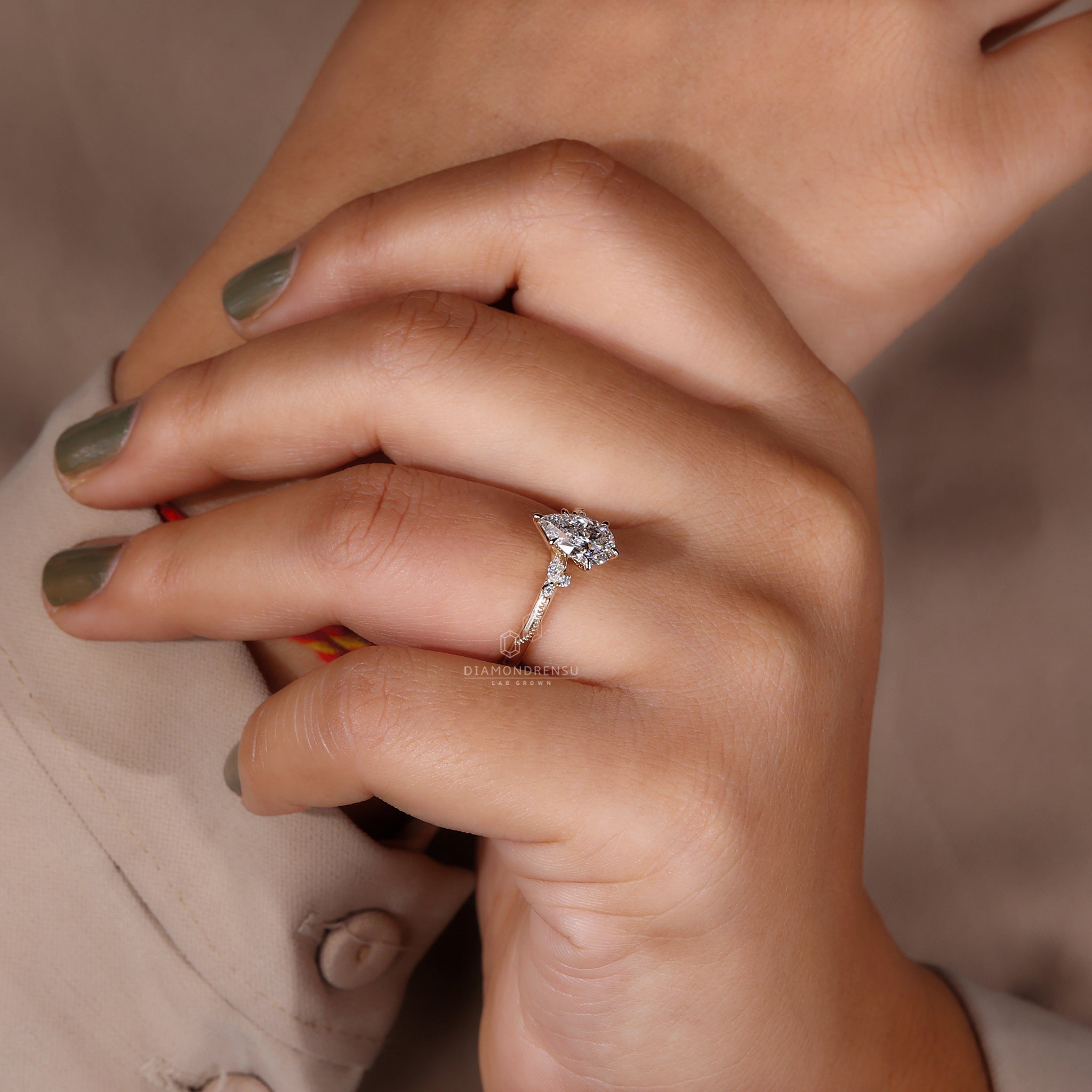 Claw prong ring featuring a pear-shaped diamond in yellow gold.