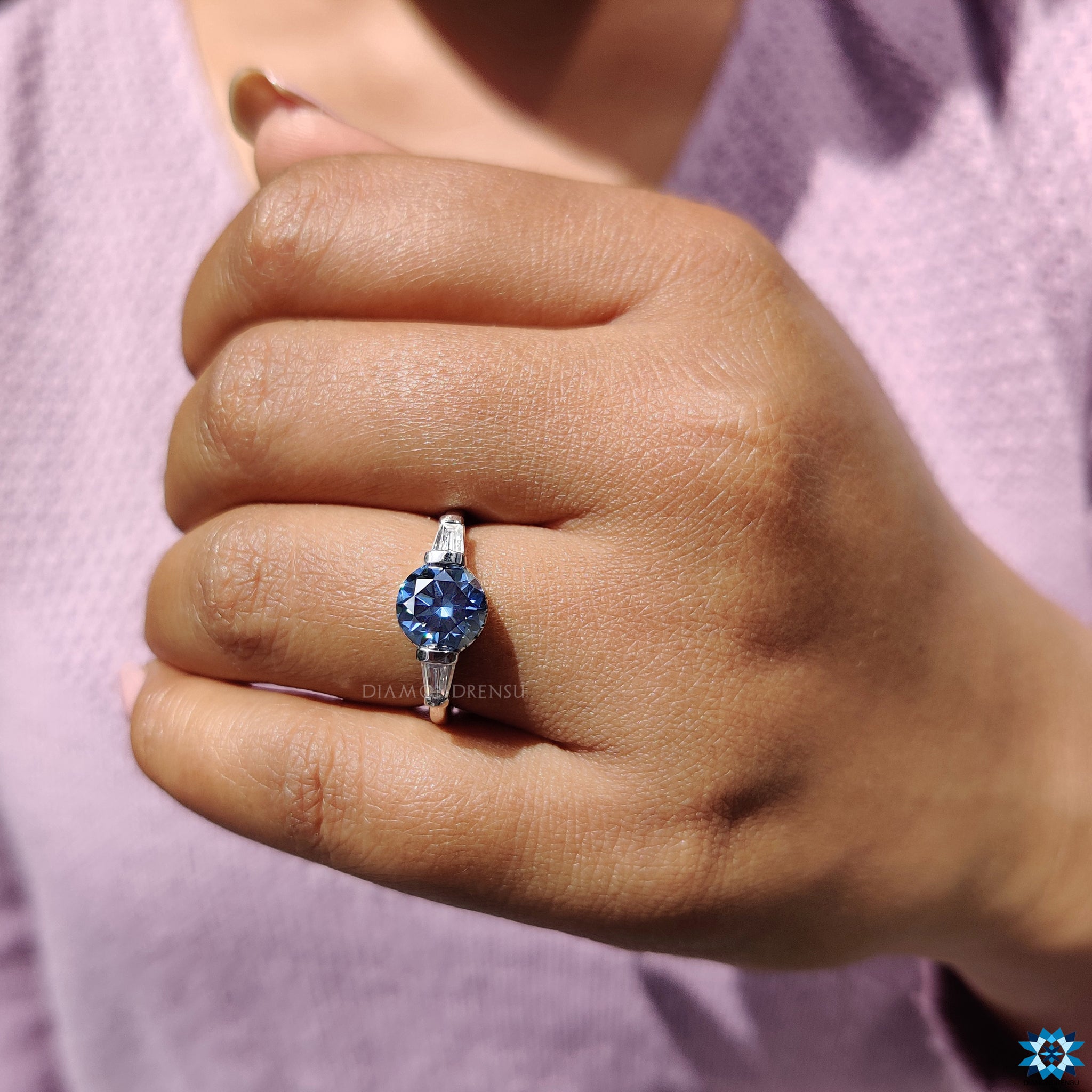 Solid bar setting ring holding round blue moissanite gemstone.
