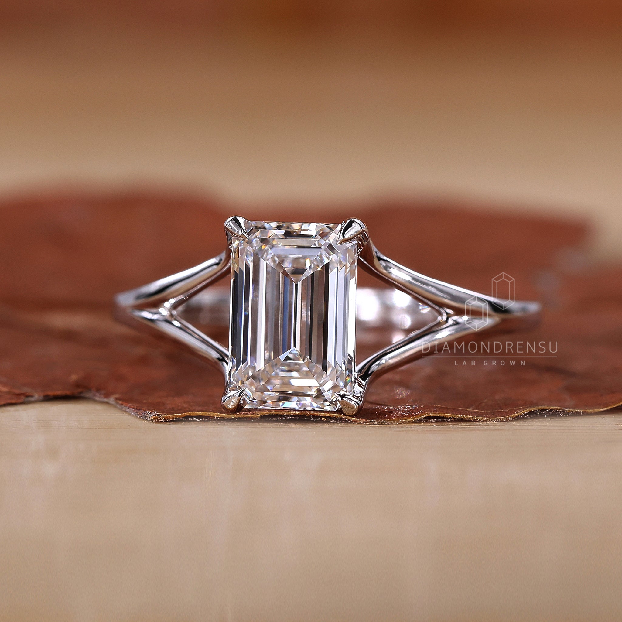 Lab grown emerald cut diamond ring with claw prongs in white gold.