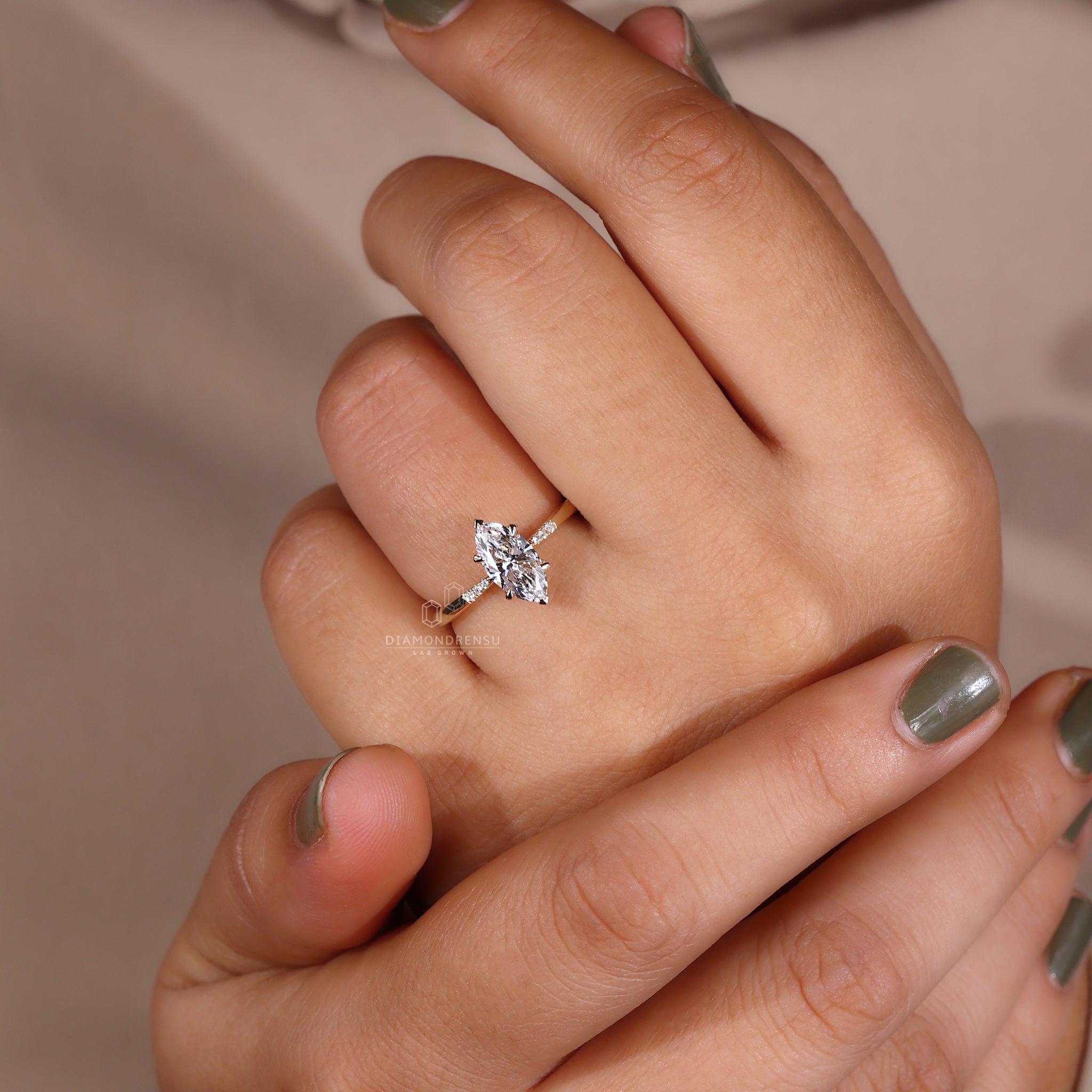 Model displaying a marquise diamond ring with round side stones and a v prong setting.