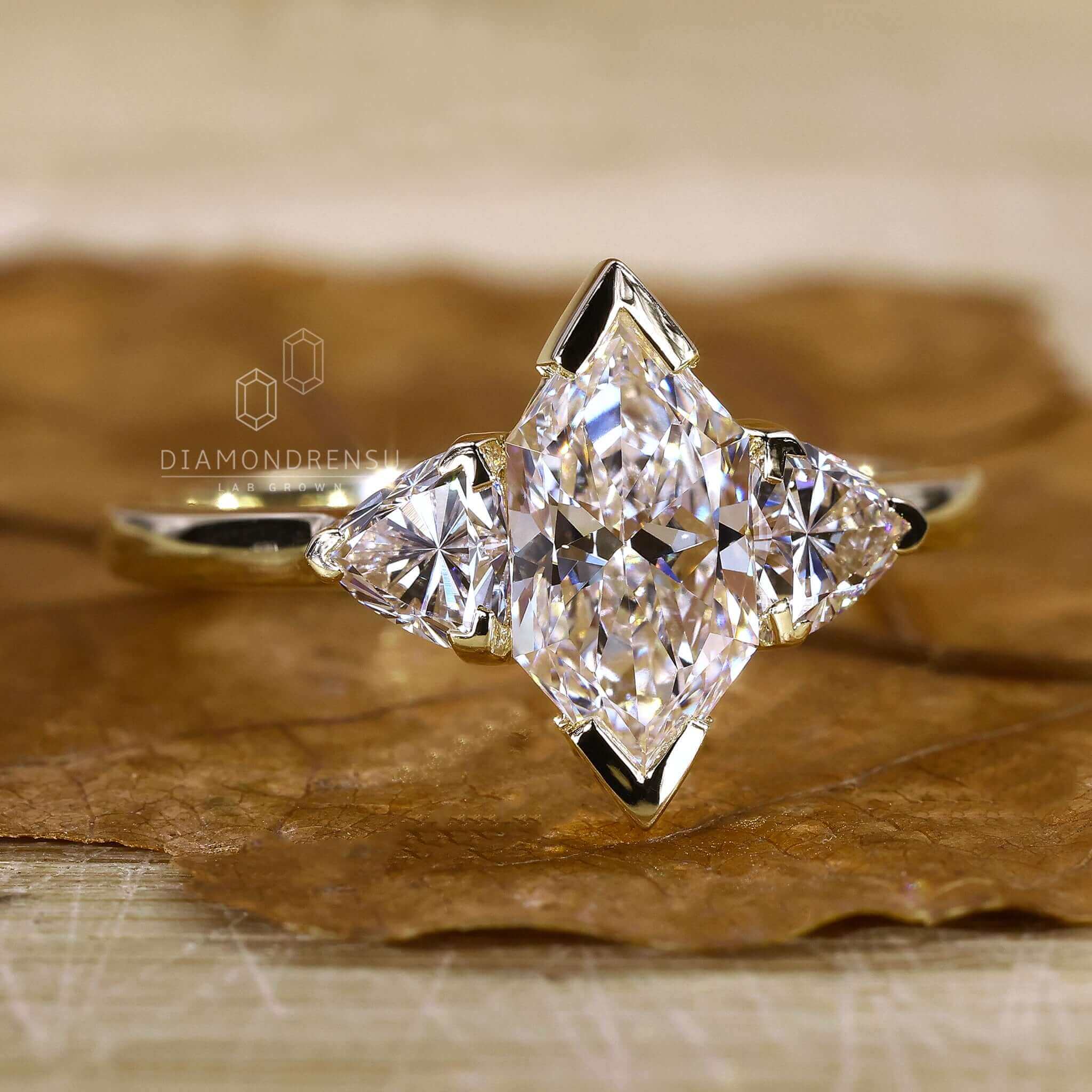 Close-up of three stone diamond ring in yellow gold setting.