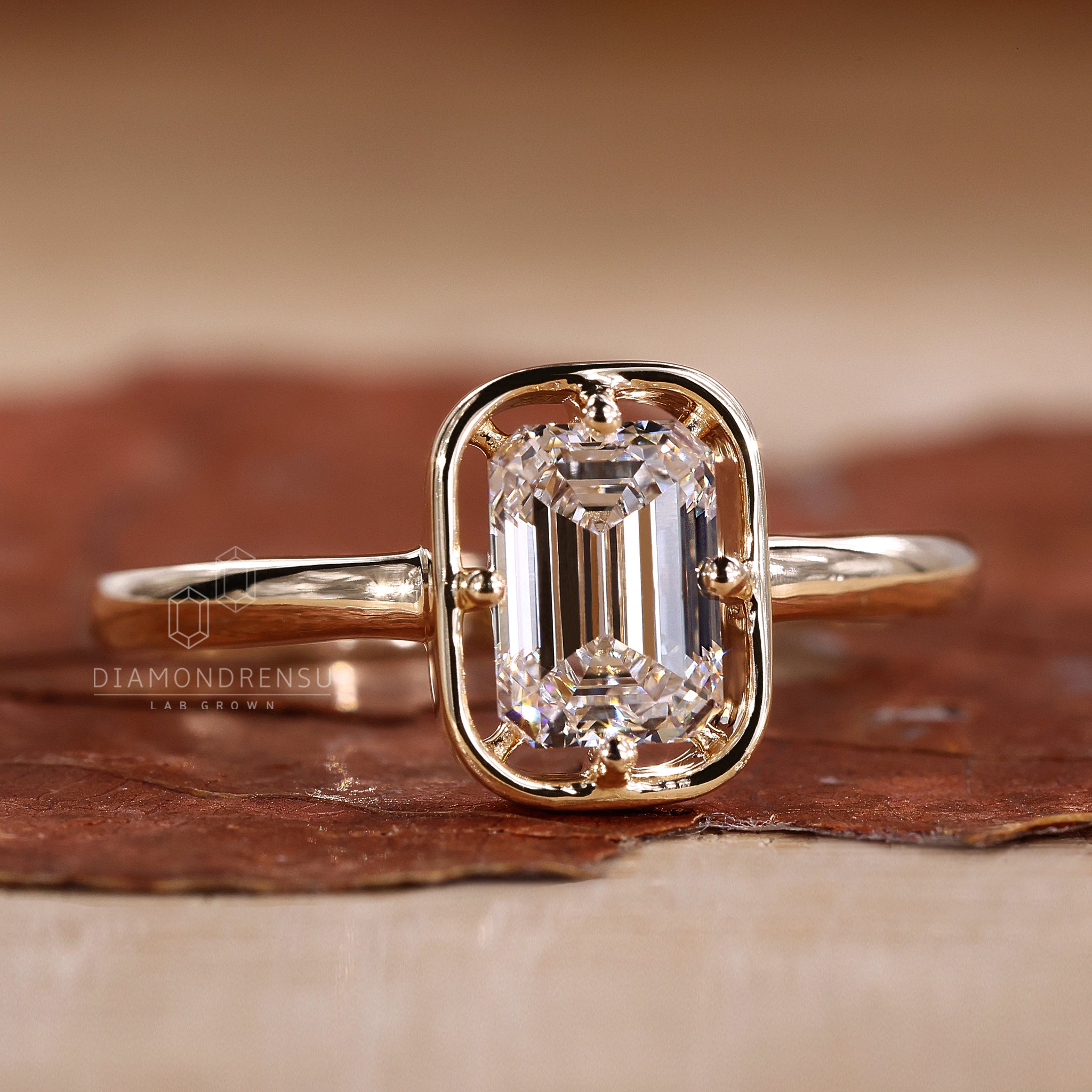 Solitaire diamond ring features one emerald cut diamond.
