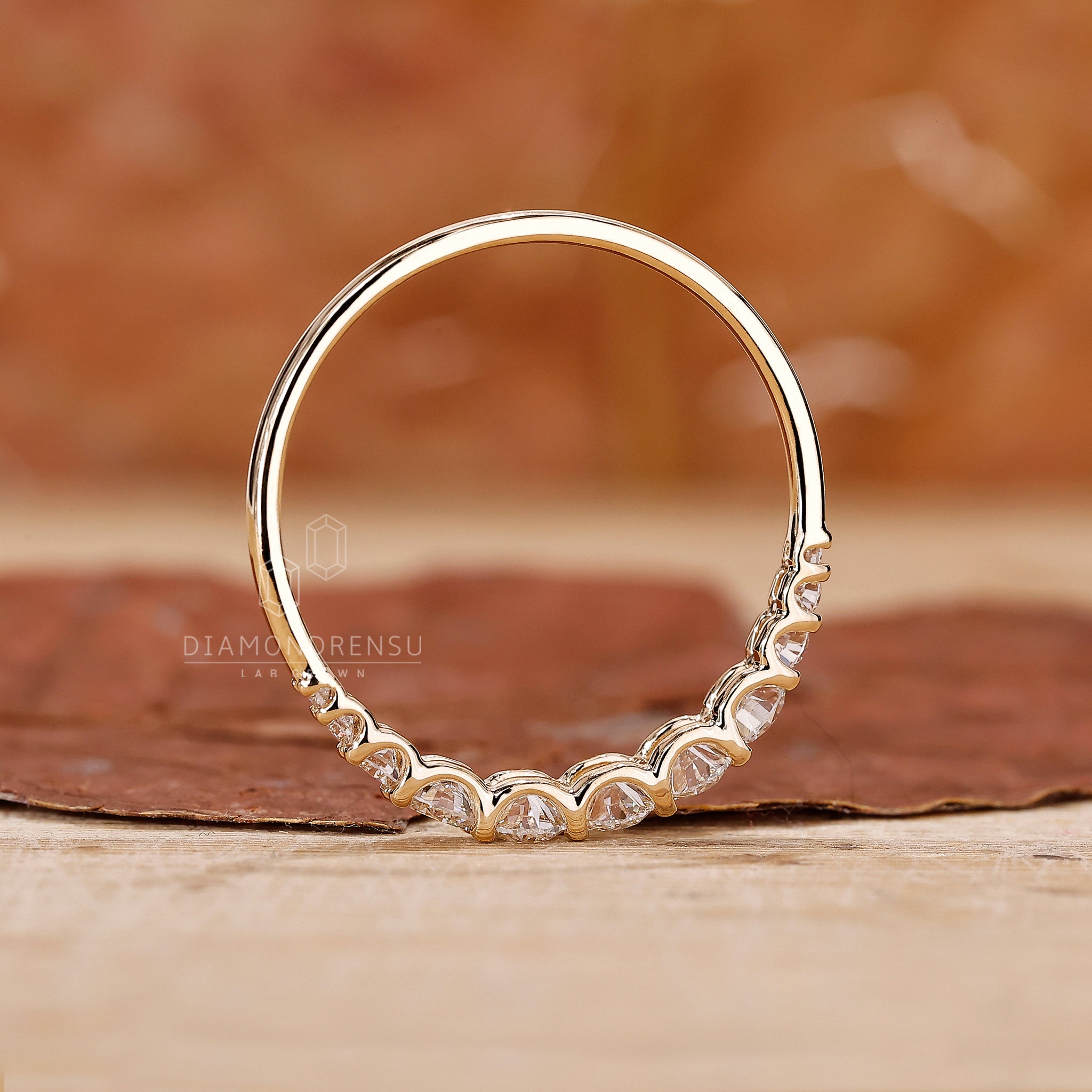 Round diamond side stone wedding band in yellow gold.
