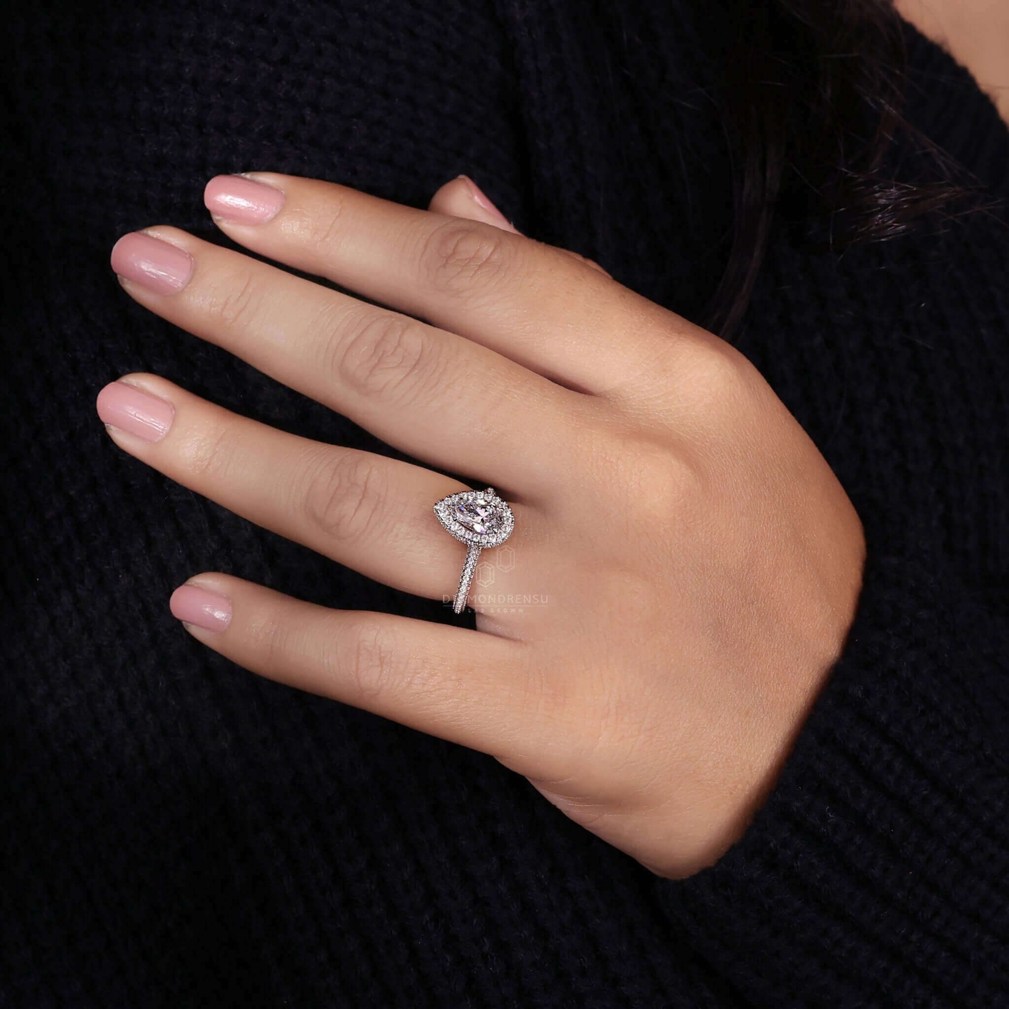 Pear shaped ring diamond featuring a halo ring ring and pave set for added brilliance.
