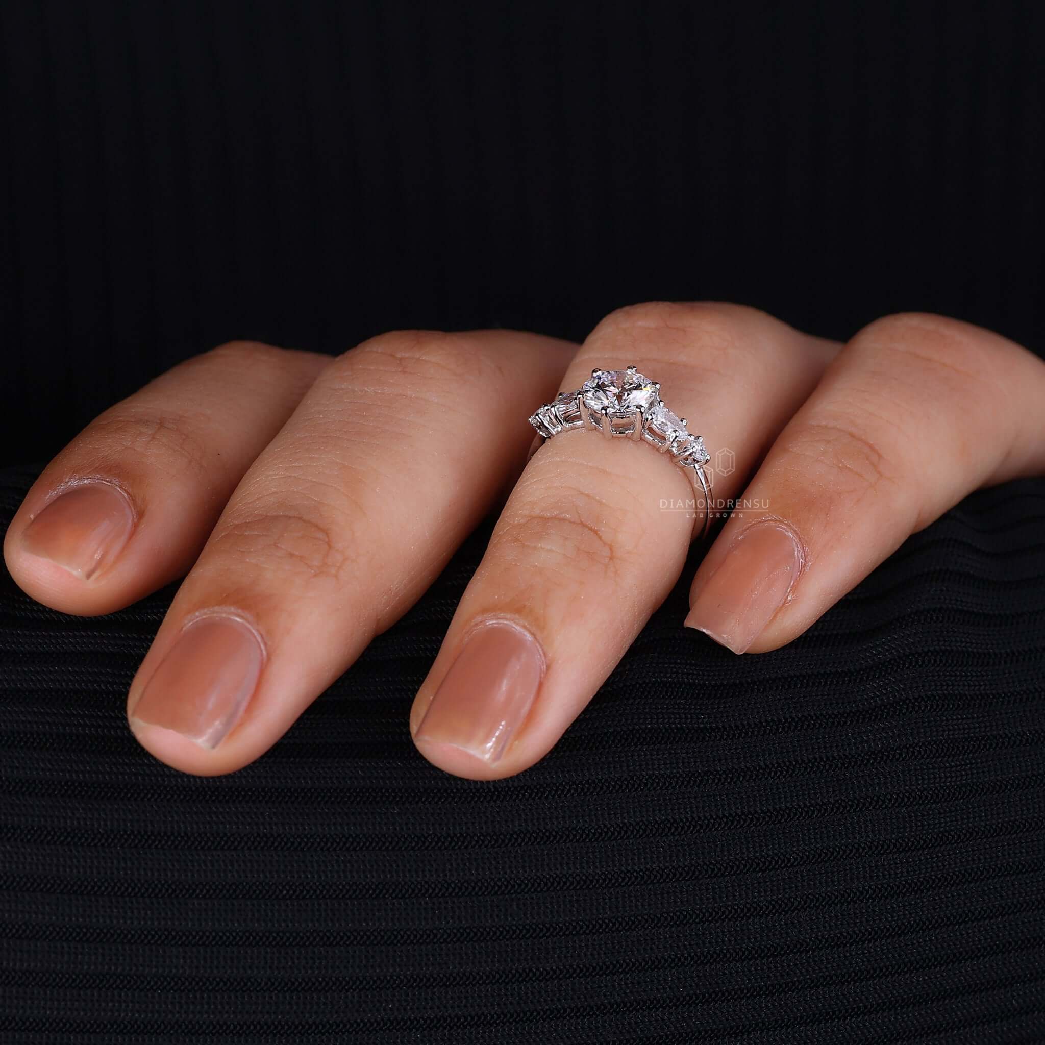 Round diamond ring with side stones that enhance its beauty and charm.