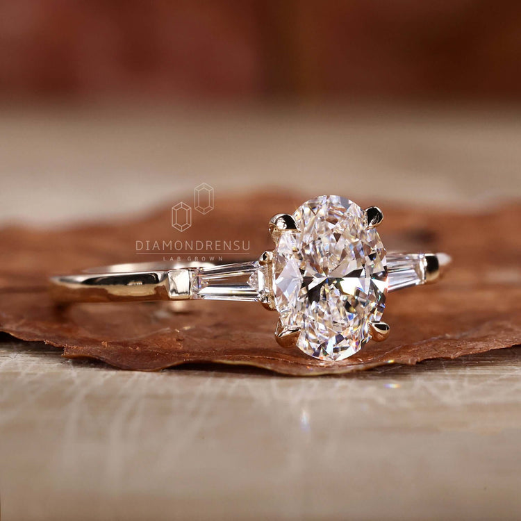 Oval shaped ring featuring a unique three stone diamond setting, crafted as a handmade jewelry piece.