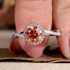 Halo diamond engagement ring with a pink round diamond design.