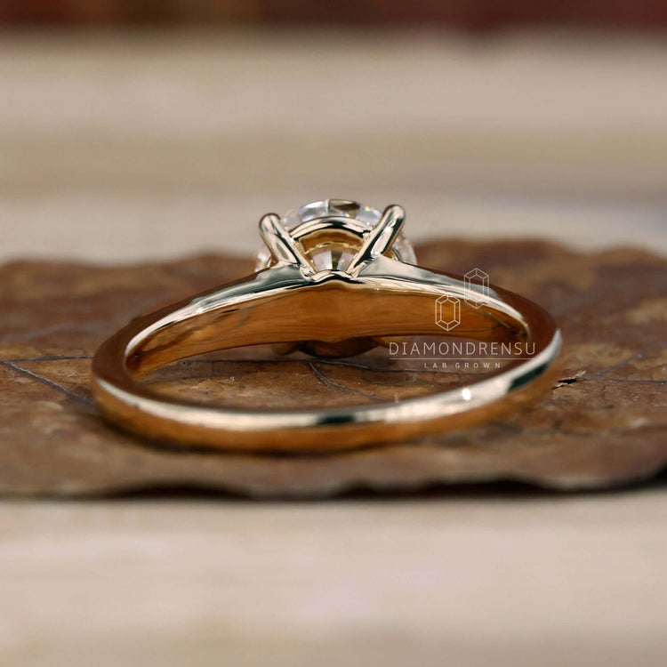 Round diamond engagement ring with pave diamonds and a tapered band, ideal for modern sophistication and charm.
