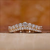Curved diamond wedding band in yellow gold.

