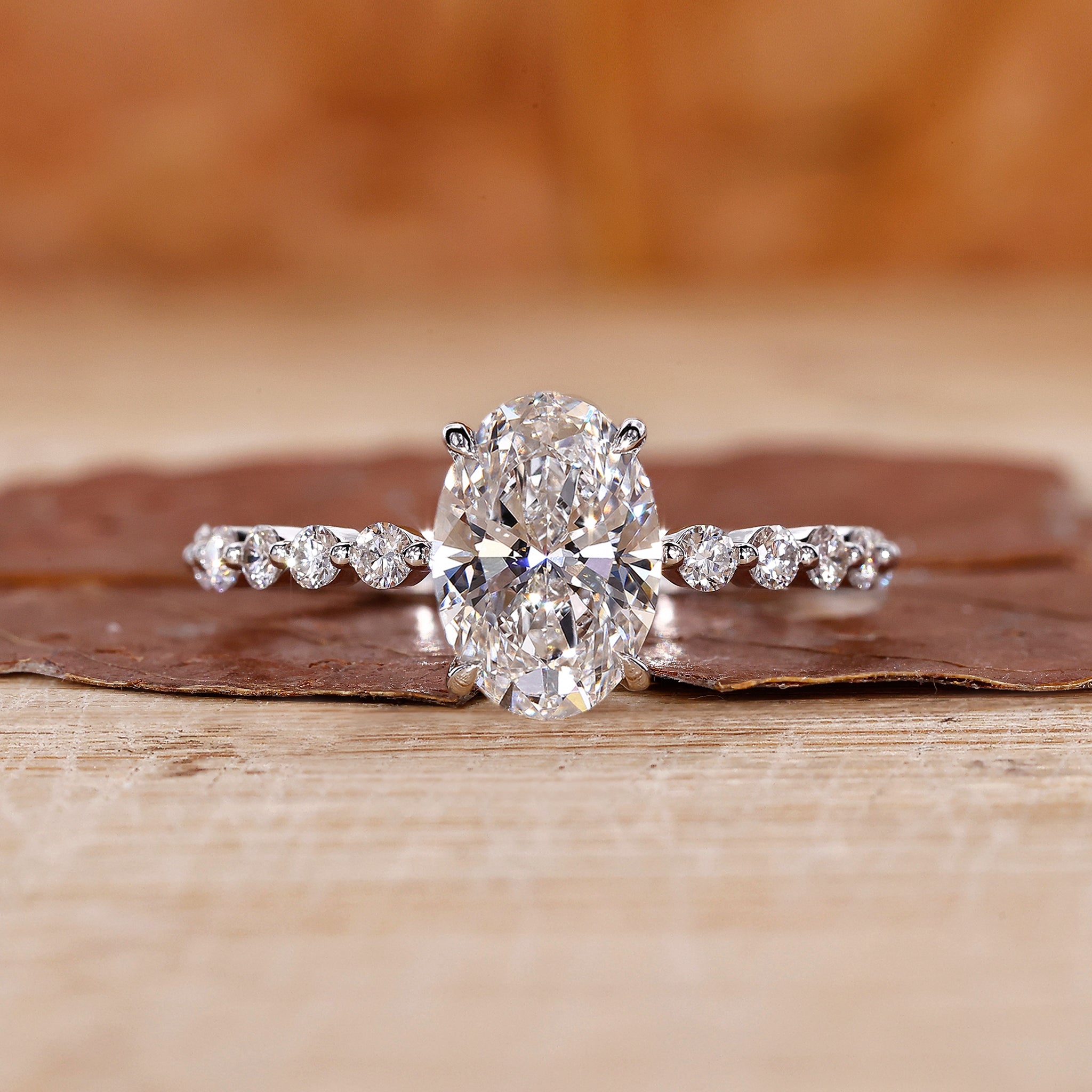 Oval diamond engagement ring with round cut pave setting.
