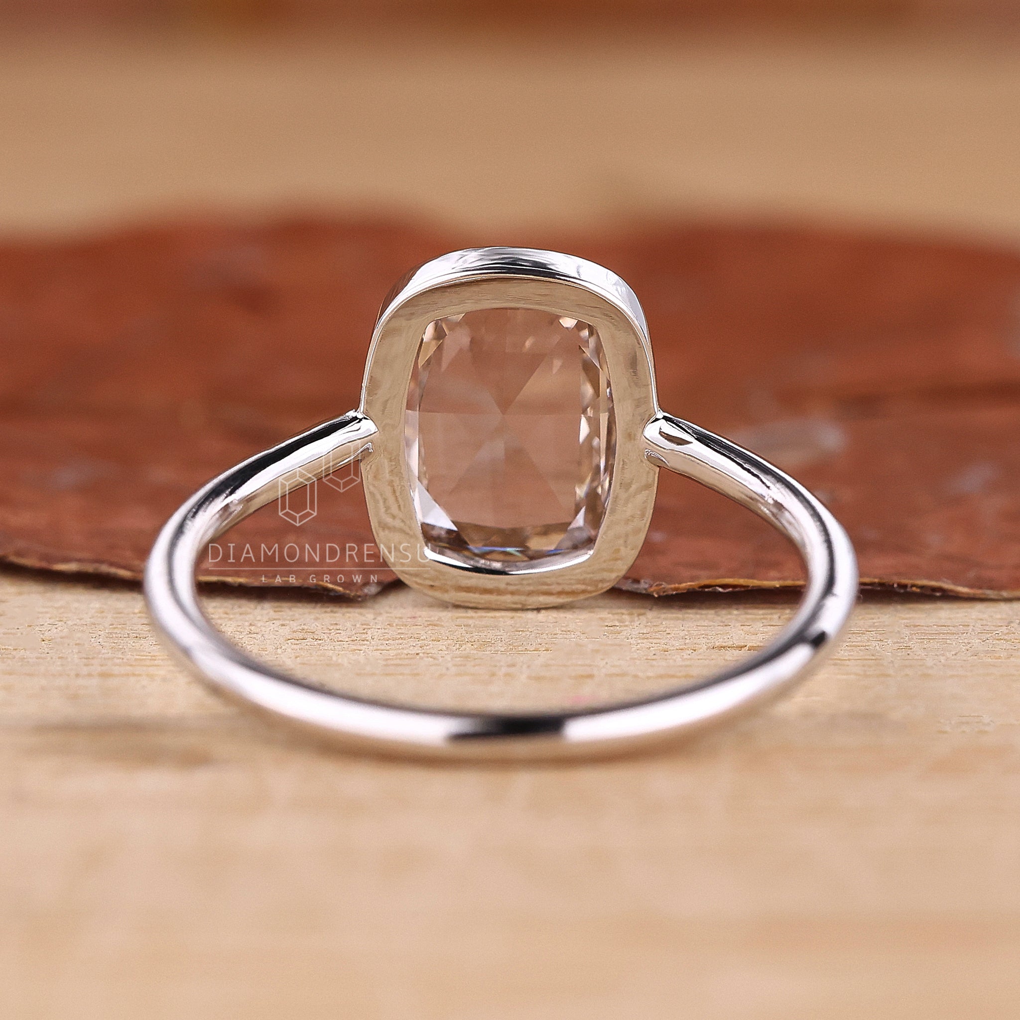 A classic bezel diamond ring elegantly placed on a display stand.