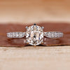 Old mine cushion cut diamond ring with pave set band in white gold.
