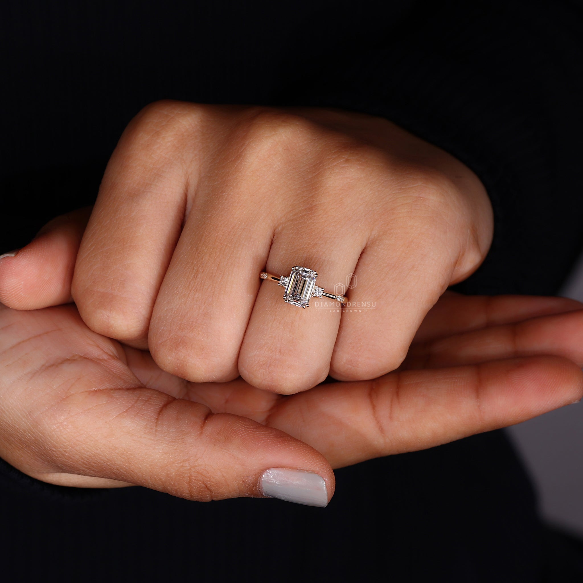 Three stone emerald cut ring under soft lighting to highlight its sparkle