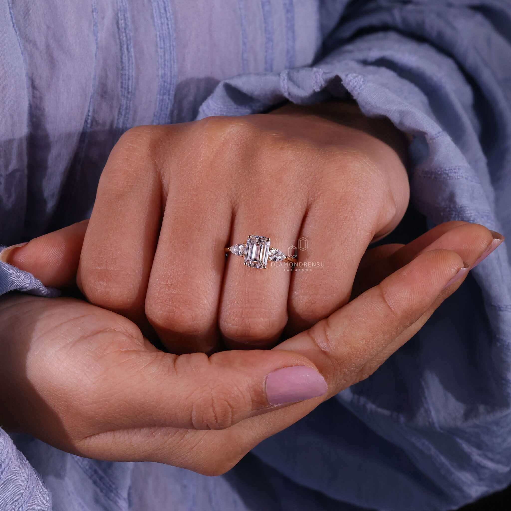 Emerald cut engagement ring in prong setting, a timeless design.