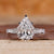 Pear diamond engagement ring with round side diamond in white gold.
