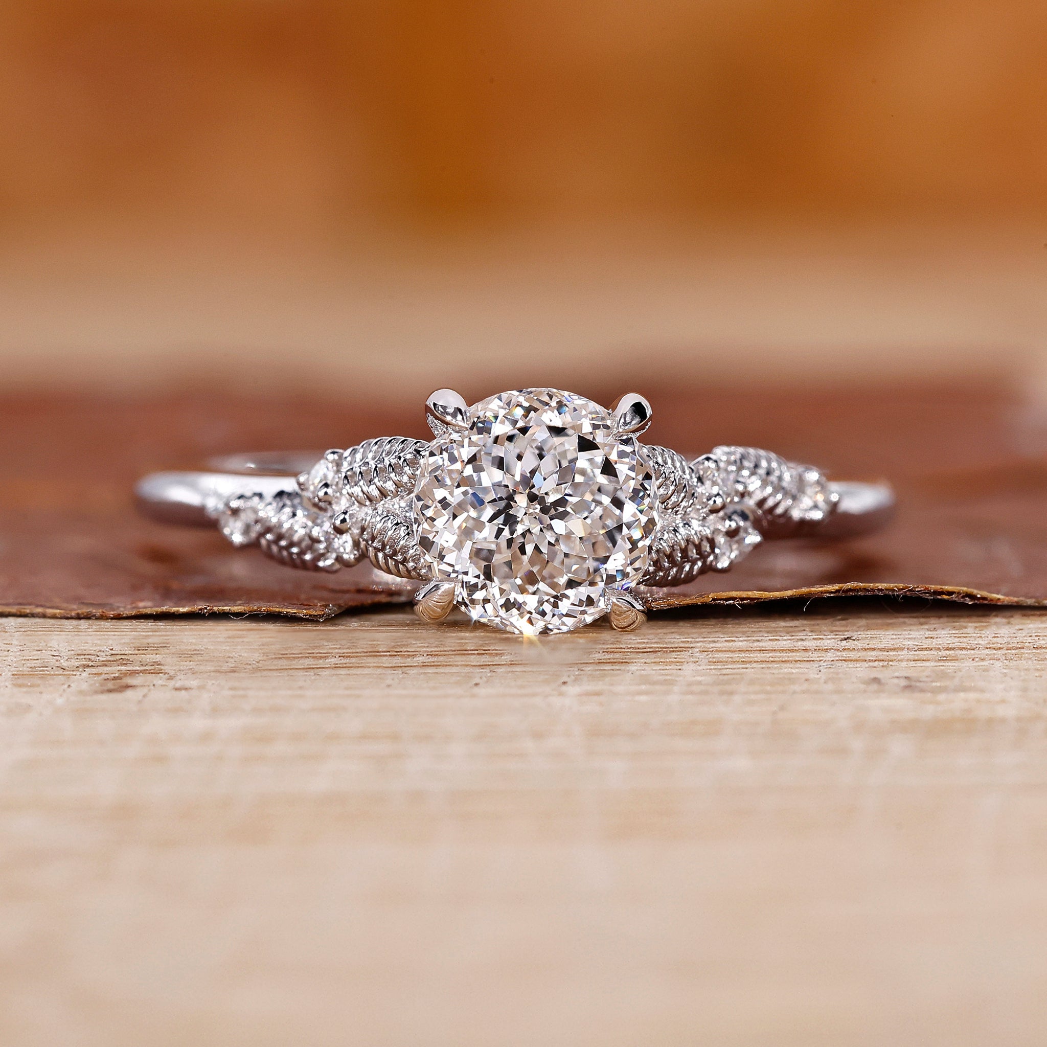Portuguese diamond engagement ring with round side diamond in white gold.
