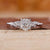 Portuguese diamond engagement ring with round side diamond in white gold.

