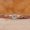 Round diamond ring with twisted shank in rose gold for UK engagement ring.
