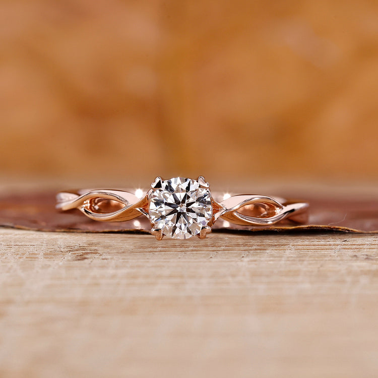 Round diamond ring with twisted shank in rose gold for UK engagement ring.
