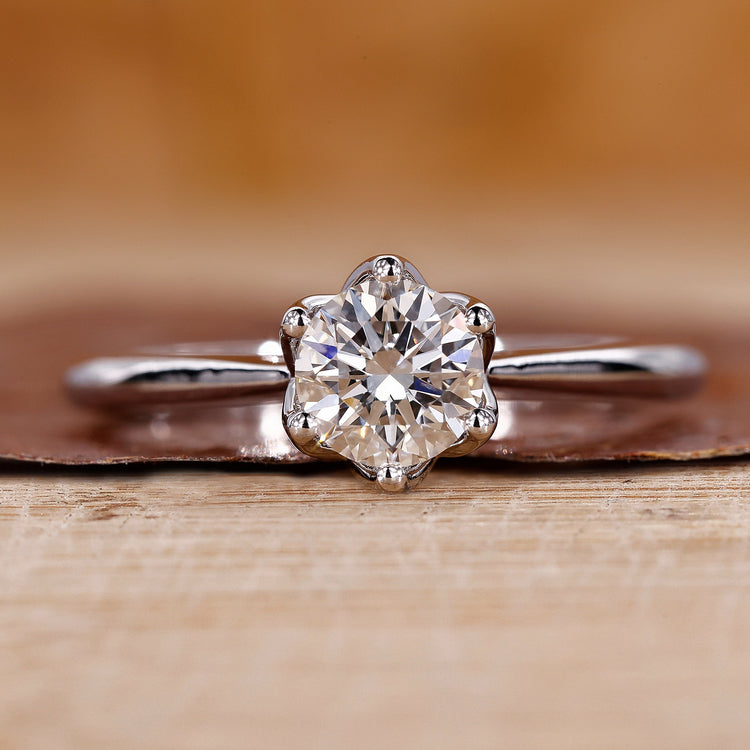 Tulip setting engagement ring with round cut diamond in white gold.
