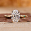 Gold oval diamond engagement ring with hidden halo and round side stones.
