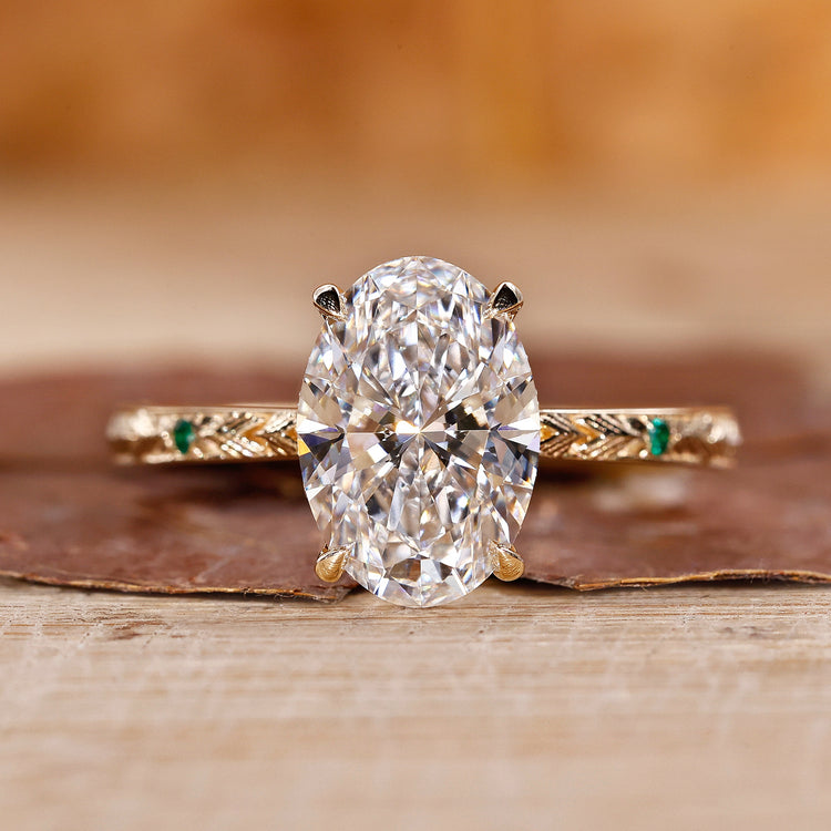 Gold oval diamond engagement ring with hidden halo and round side stones.
