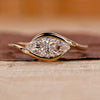 East west engagement ring featuring a marquise diamond in yellow gold.
