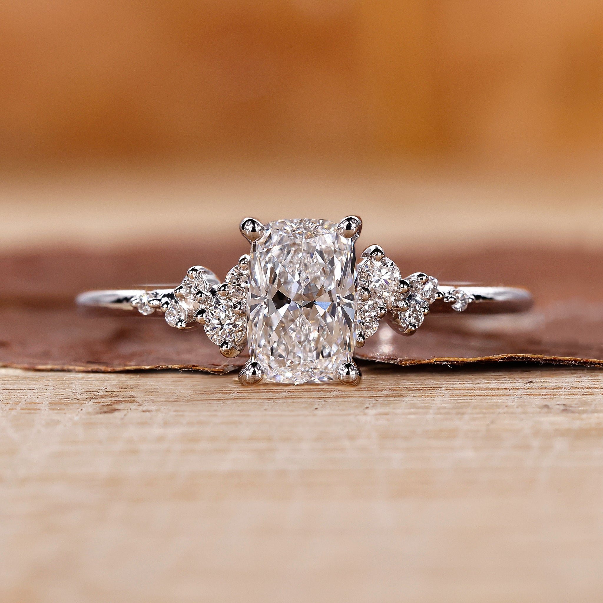 Elongated cushion ring with round side stones in white gold.
