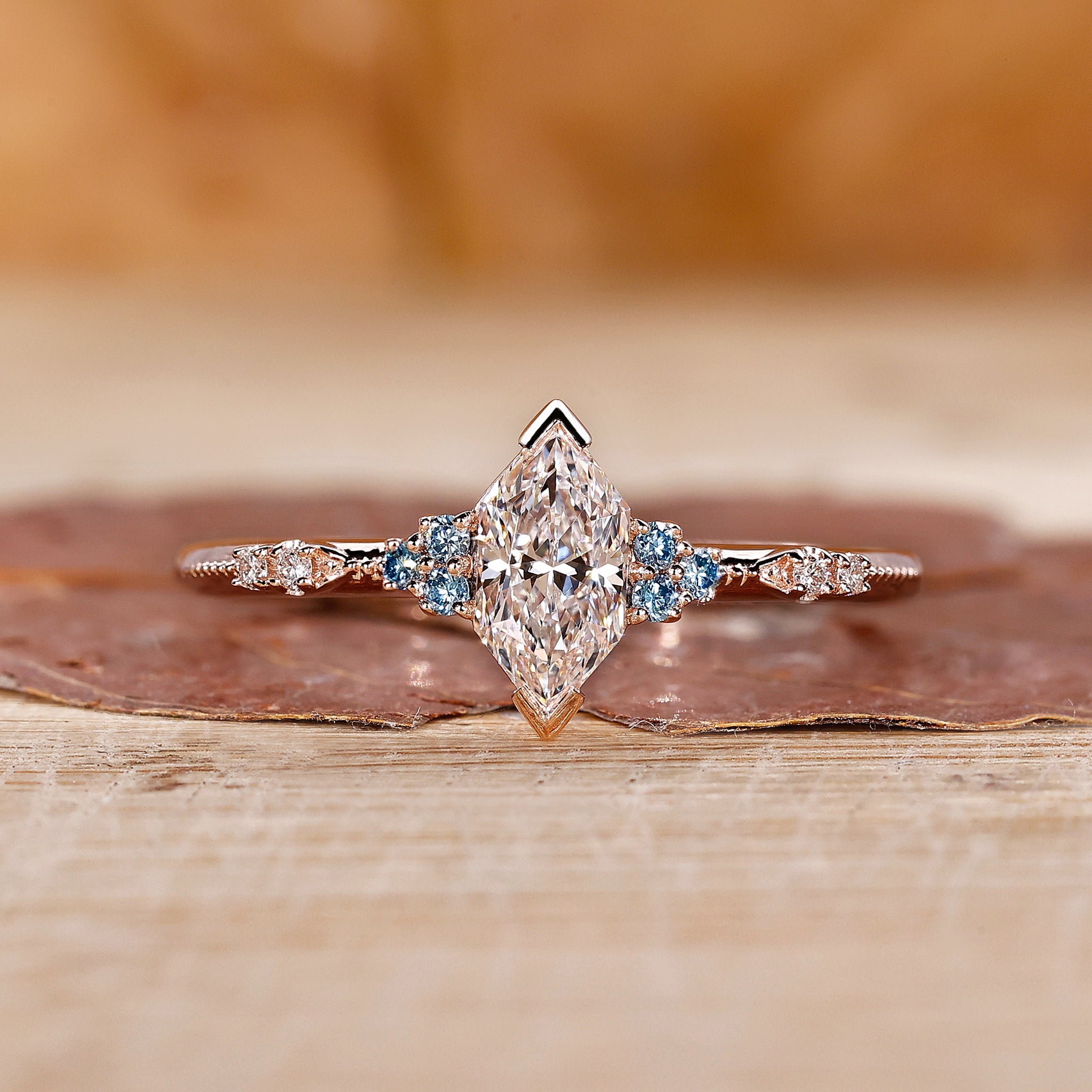 Dutch marquise diamond ring features cyan blue side stones.
