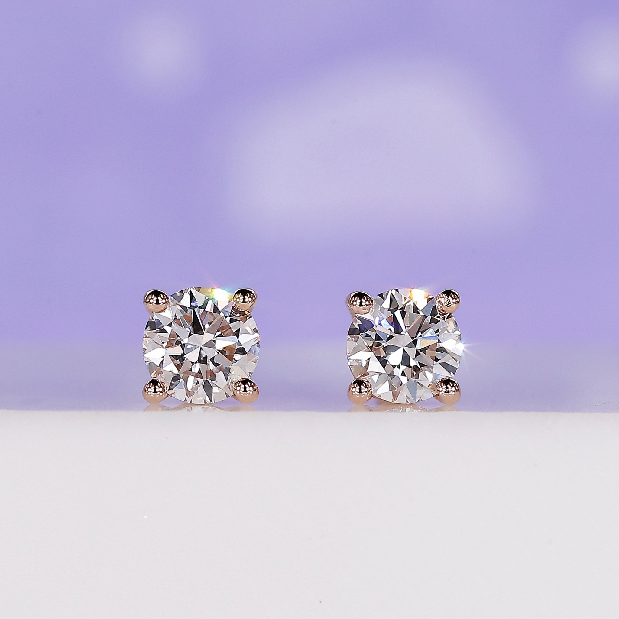 Diamond stud earrings for women crafted in rose gold with round diamonds.