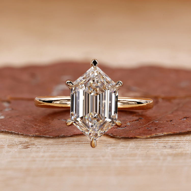 Gold solitaire engagement ring with hexagon diamond.
