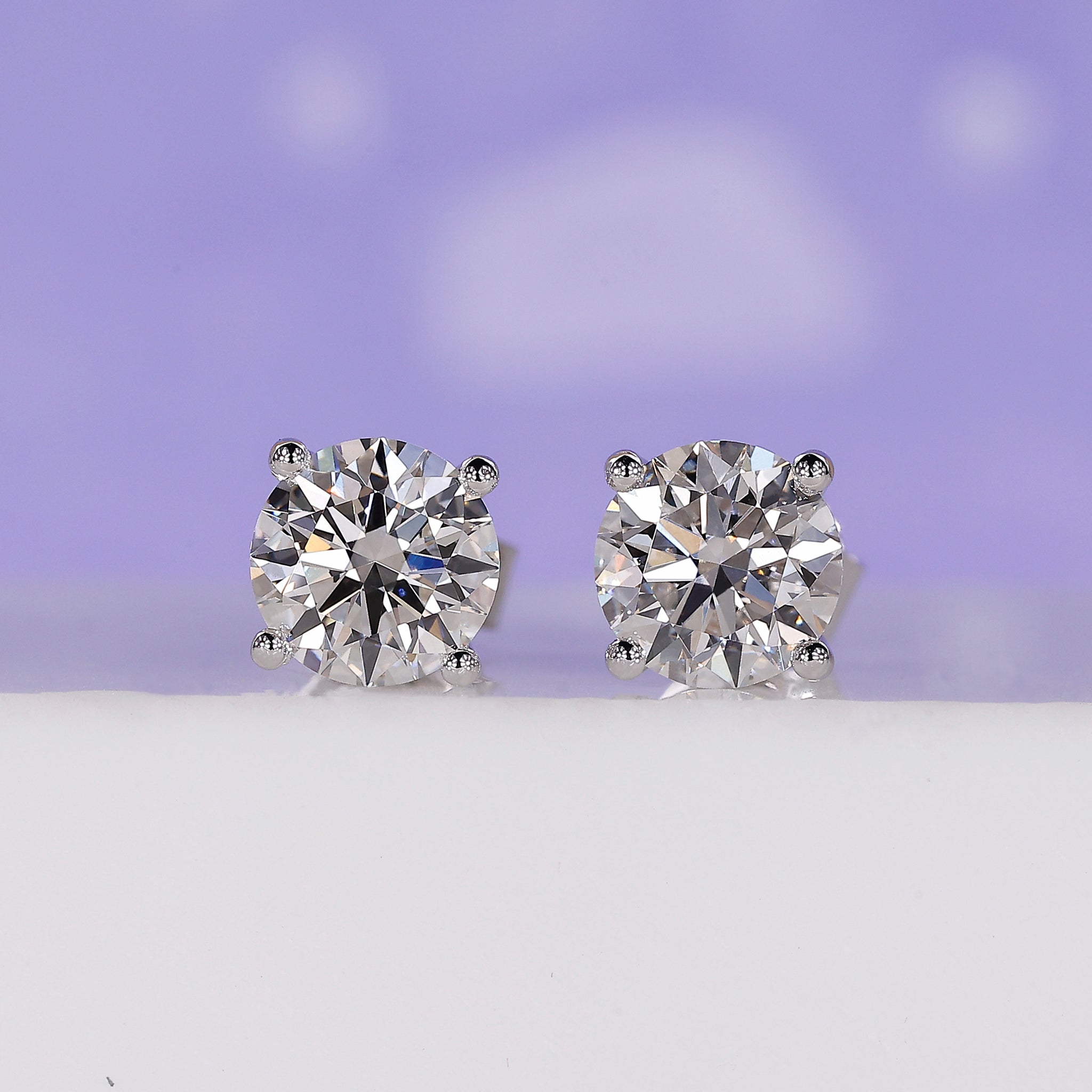 Gold stud earrings for women featuring round lab grown diamonds in 4 prong setting.