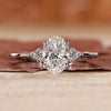 Oval cut engagement ring with round side stones in white gold.
