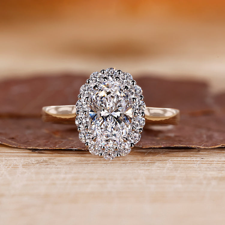 Oval diamond engagement ring with round cut halo.
