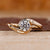Bypass engagement ring with round diamond center stone.
