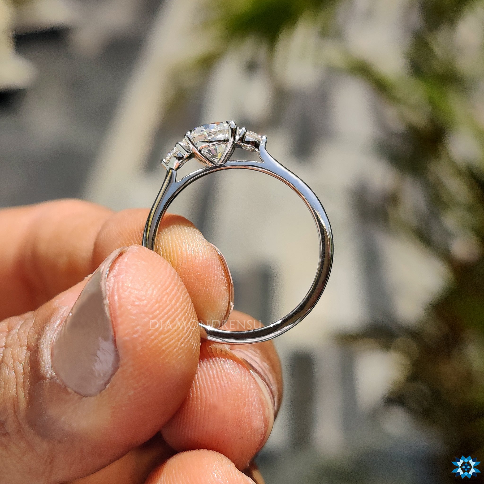 Handmade jewellery featuring round moissanite with prong and side stones.
