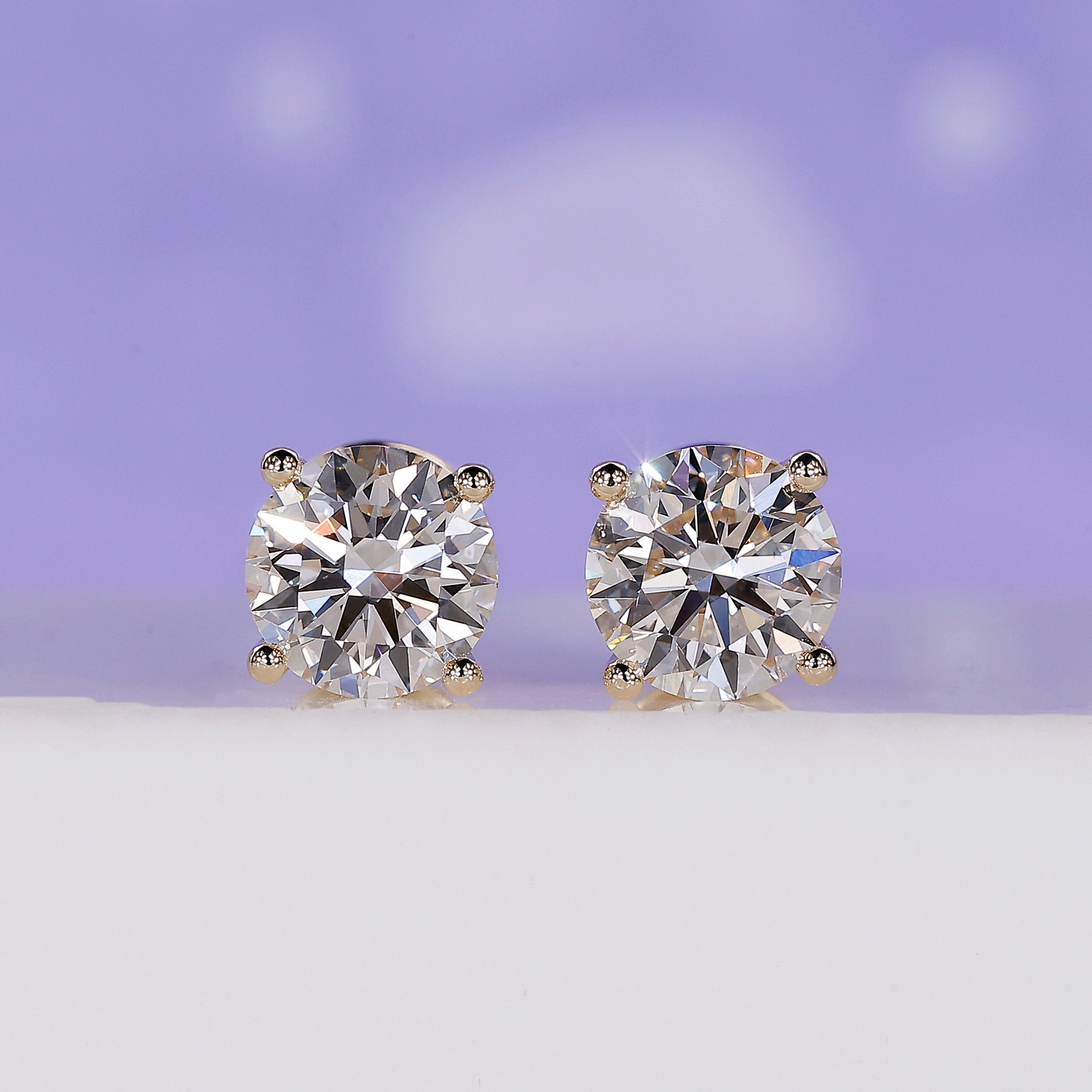 Gold diamond stud earrings with round lab grown diamonds in 4 prong setting.
