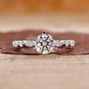 Round cut engagement ring with round and marquise side stones.
