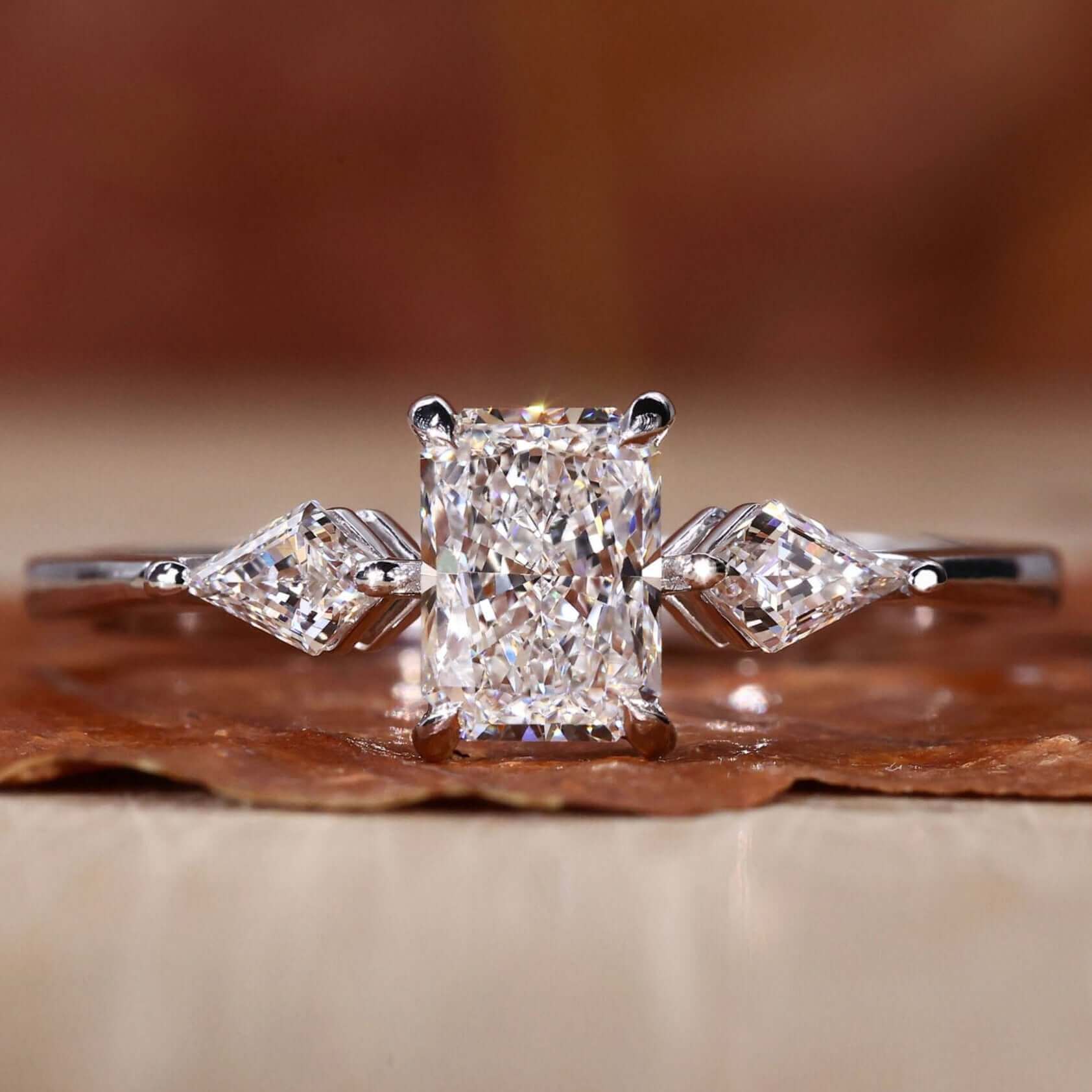 Radiant cut diamond ring featuring a classic three stone engagement ring design.