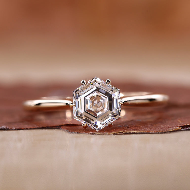 Solitaire diamond ring with tapered ring shank in yellow gold.
