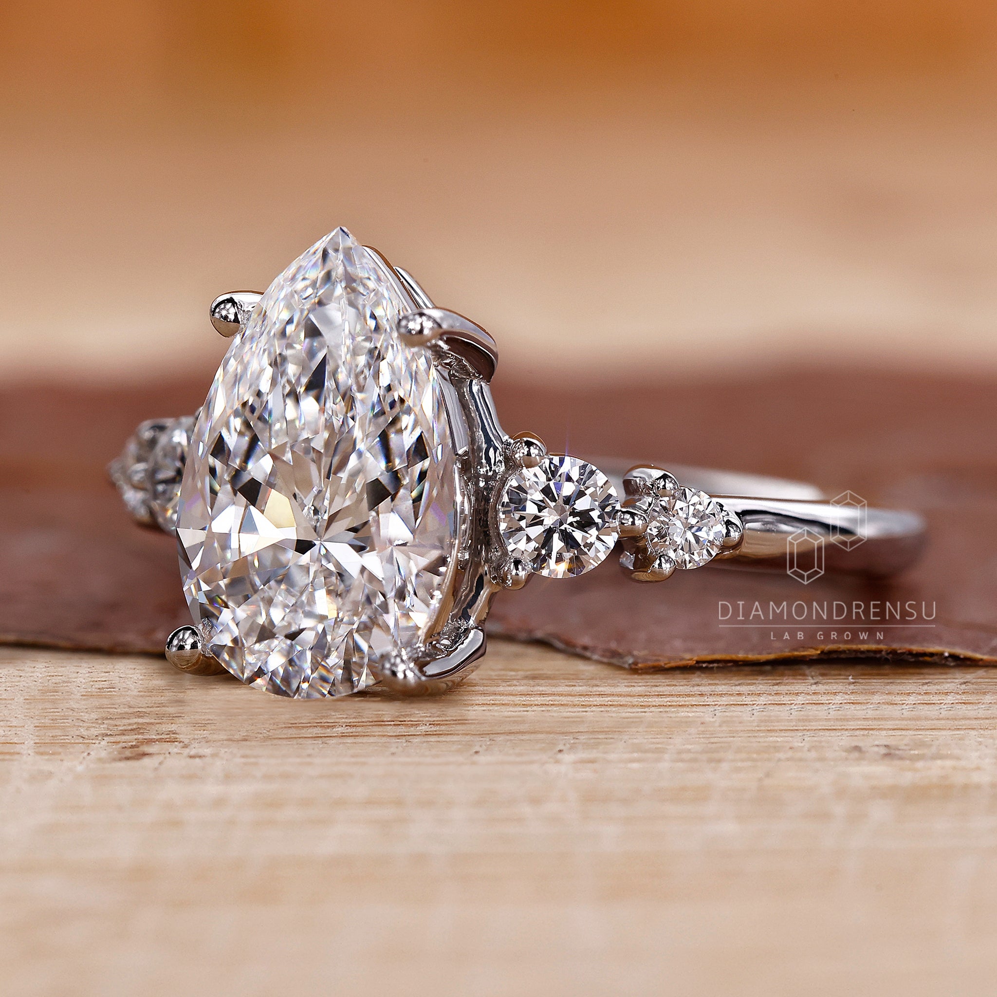 Buy engagement ring online with pear cut diamond and five stone setting.
